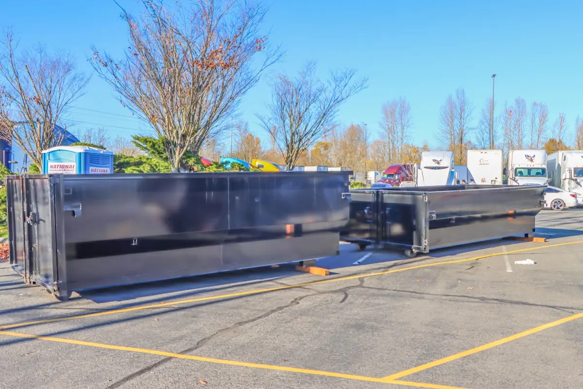 Professional dumpster rental service with roll-off container on residential driveway in East Bay